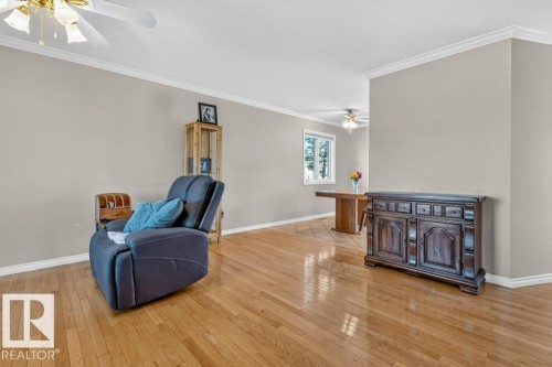 Hardwood flooring, crown molding, ceiling fan with light fixture, neutral wall color, and white trim - 14527 32 Street Nw, Edmonton, AB 