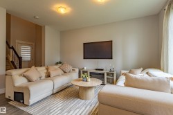 Open-concept living area featuring light-toned walls, wood-finish flooring, and recessed ceiling lighting - 