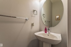 Pedestal sink with chrome faucet, complemented by a large oval mirror - 