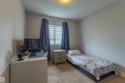 Bedroom featuring neutral wall tones, carpeted flooring, a window with horizontal blinds, and a flush-mount ceiling light fixture - 