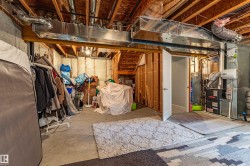 Unfinished basement featuring exposed wood joists and concrete flooring - 