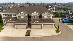 Townhome units featuring composite shingle roofing, beige siding, and stone accents - 