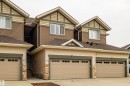 Contemporary multi-unit dwelling with integrated garages, two-tone siding, decorative stone accents, and peaked rooflines - #14 4835 Wright Dr Sw Sw, Edmonton, AB  - Outdoor 