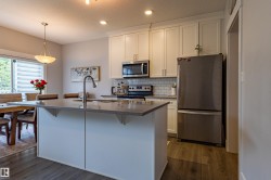 Kitchen featuring a central island with an undermount sink and gooseneck faucet - 