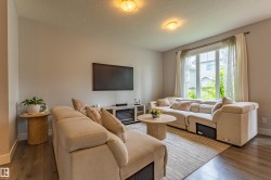 Living area featuring wood-finish flooring, light neutral wall tones, and recessed ceiling lighting - 
