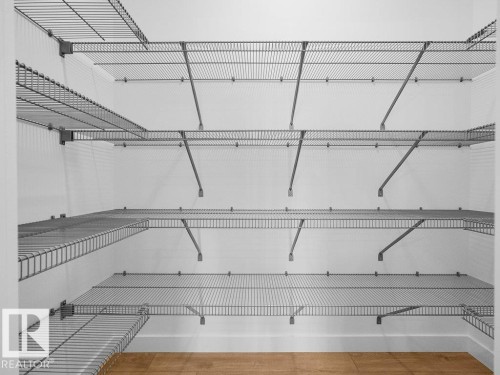 Integrated wire shelving system with multiple tiers, corner shelving, and wood-finish flooring - 912 17 Ave Nw, Edmonton, AB 