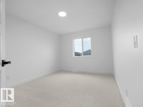 Recessed ceiling light, white painted walls, light-colored carpet, and a white framed window - 912 17 Ave Nw, Edmonton, AB 