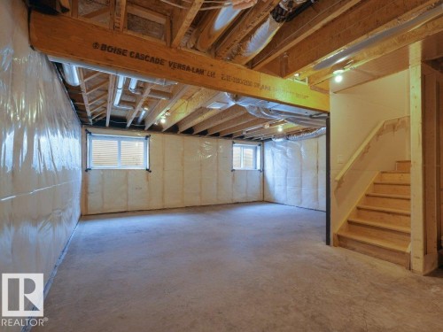 Unfinished lower level with exposed wood joists, concrete flooring, and multiple windows - 912 17 Ave Nw, Edmonton, AB 