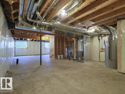 Unfinished basement featuring exposed wood joists, concrete flooring, and visible ductwork - 912 17 Ave Nw, Edmonton, AB 