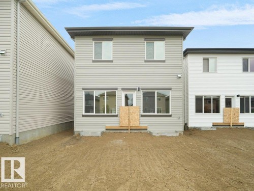 Two-story residence featuring light gray siding and a dark gray roofline - 912 17 Ave Nw, Edmonton, AB 
