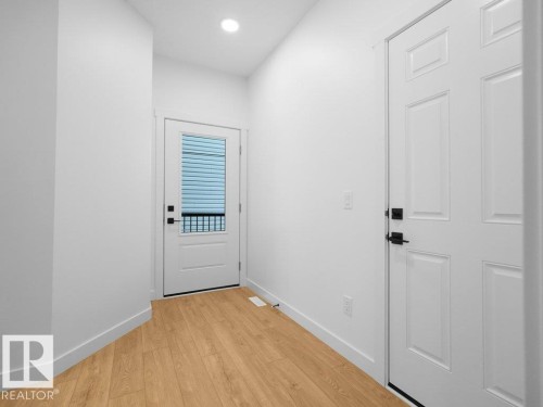 Recessed ceiling lighting, durable wood-finish flooring, white paneled doors, and contemporary black hardware - 912 17 Ave Nw, Edmonton, AB 