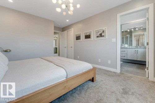 Recessed lighting and a modern sputnik chandelier illuminate this carpeted room - #45 16903 68 St Nw, Edmonton, AB 