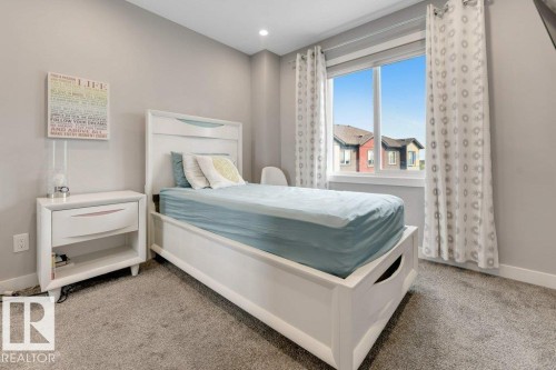 Spacious room featuring neutral wall paint, carpet flooring, a large window, and recessed lighting - #45 16903 68 St Nw, Edmonton, AB 