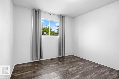 Wood-finish flooring with white walls and a window featuring natural light - 13235 82 Street Nw, Edmonton, AB 
