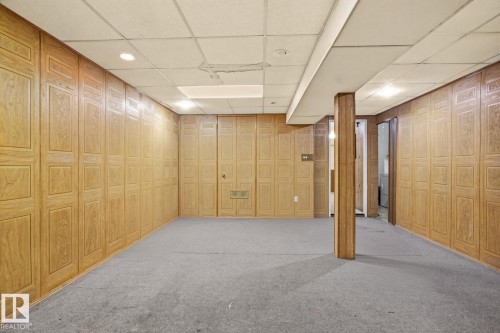 Wood-paneled walls, dropped ceiling with recessed lighting, and carpeted flooring - 13235 82 Street Nw, Edmonton, AB 