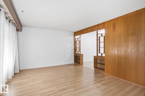 Wood-finish flooring, white walls, wood paneling, and a decorative room divider with built-in shelving - 13235 82 Street Nw, Edmonton, AB 