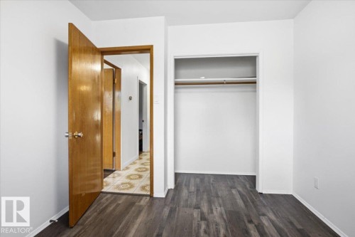 Wood-finish flooring throughout, bright white walls, and a built-in closet with hanging rod - 13235 82 Street Nw, Edmonton, AB 