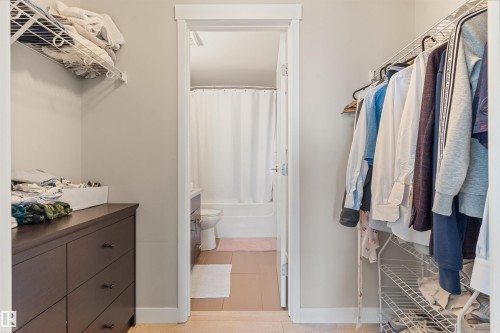 Walk-in closet featuring built-in wire shelving and a dark wood-finish dresser - #2205 10226 104 St Nw, Edmonton, AB - Indoor With Storage