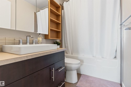 Bathroom featuring a rectangular vessel sink, dark wood-finish vanity, and a light-colored countertop - #2205 10226 104 St Nw, Edmonton, AB - Indoor Photo Showing Bathroom