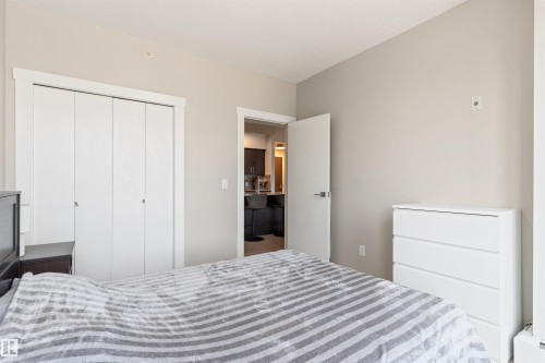 Bedroom featuring light neutral wall paint, white trim, and a white bi-fold closet - #2205 10226 104 St Nw, Edmonton, AB - Indoor Photo Showing Bedroom