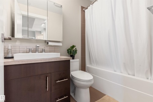 Bathroom featuring a dark wood-finish vanity with a vessel sink, chrome faucet, and mirrored medicine cabinet - #2205 10226 104 St Nw, Edmonton, AB - Indoor Photo Showing Bathroom