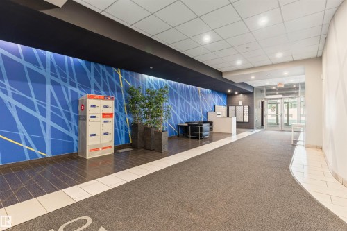 Modern lobby entrance featuring a distinctive blue accent wall with linear patterns - #2205 10226 104 St Nw, Edmonton, AB - Indoor Photo Showing Other Room
