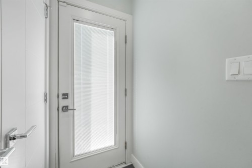 White interior door with frosted glass panel and chrome hardware - 6453 177A Avenue Nw, Edmonton, AB 