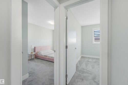 Interior room with light gray walls, white trim, and patterned gray carpeting - 6453 177A Avenue Nw, Edmonton, AB 