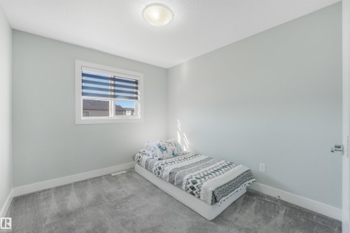Recessed window with horizontal blinds, overhead flush mount lighting, light gray wall paint, and gray carpeting - 6453 177A Avenue Nw, Edmonton, AB 