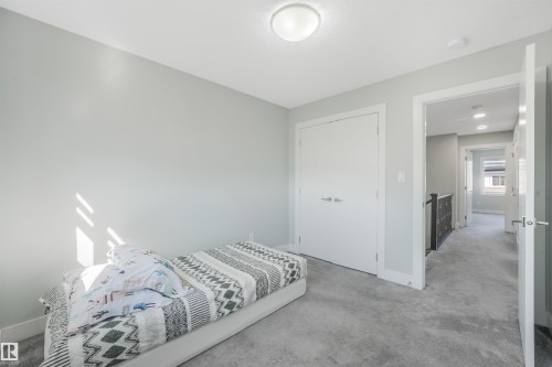 Neutral-toned walls, plush carpeting, and a built-in closet with double doors - 6453 177A Avenue Nw, Edmonton, AB 