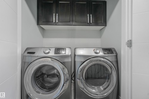 Stackable laundry appliances with dark wood-finish cabinetry - 6453 177A Avenue Nw, Edmonton, AB 