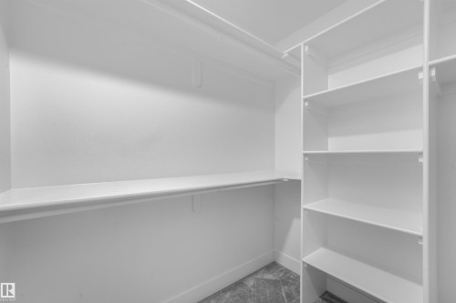 Custom closet system featuring built-in shelving, hanging rods, and corner organization - 6453 177A Avenue Nw, Edmonton, AB 