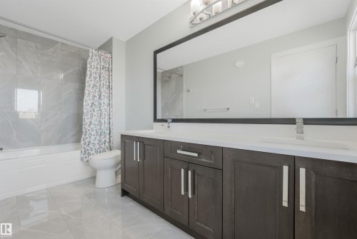 Dual vanity with undermount sinks, white countertop, and dark wood-finish cabinetry - 6453 177A Avenue Nw, Edmonton, AB 