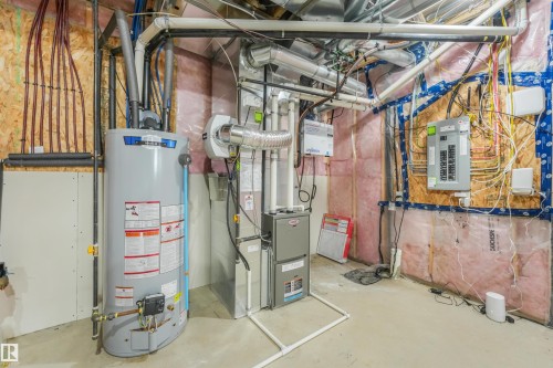 Utility room featuring a water heater, furnace system, and electrical panel - 6453 177A Avenue Nw, Edmonton, AB 