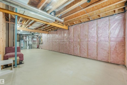 Unfinished basement with exposed wood framing, concrete flooring, insulated walls, and visible ductwork - 6453 177A Avenue Nw, Edmonton, AB 