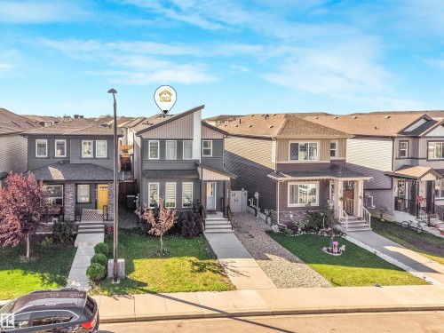Modern exterior with a distinctive sloped roofline, attached garage, and a concrete driveway - 6453 177A Avenue Nw, Edmonton, AB 