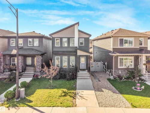 Contemporary exterior with contrasting siding, multiple large windows, and a paved walkway - 6453 177A Avenue Nw, Edmonton, AB 