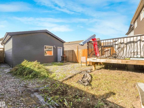 Detached garage with dark siding, exterior door, and single window - 6453 177A Avenue Nw, Edmonton, AB 