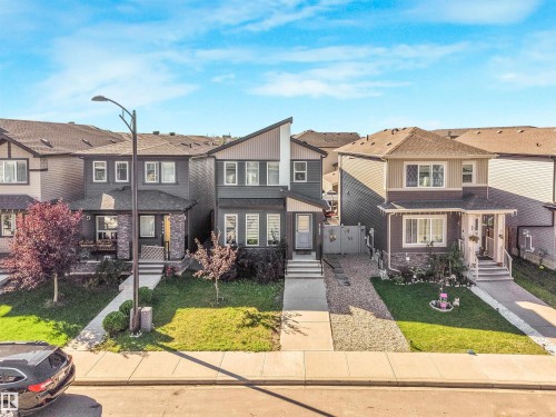 Modern exterior with a contrasting façade, partial stone detailing, and an attached front porch - 6453 177A Avenue Nw, Edmonton, AB 