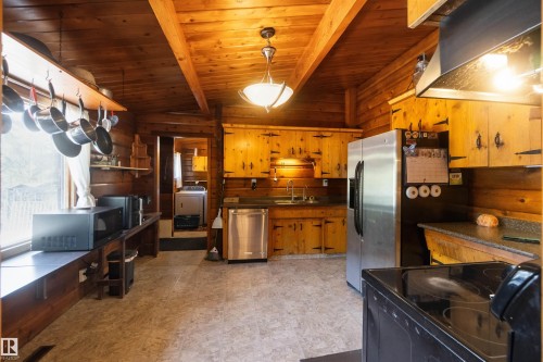 Kitchen featuring wood paneled walls and ceiling with exposed beams - 910 Hermitage Avenue, Rural Parkland County, AB - Indoor