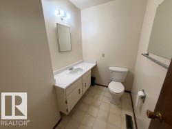 Bathroom featuring a vanity with an integrated sink, built-in cabinetry, wall-mounted mirror, and tile flooring - 