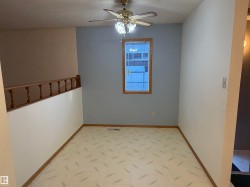 Recessed window with wood-finish trim, ceiling fan with integrated lighting, and patterned vinyl flooring - 