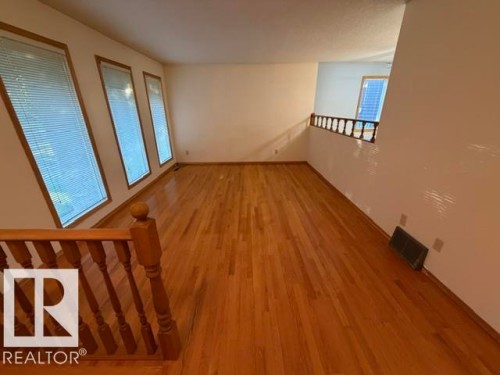 Hardwood flooring throughout, multiple windows with blinds, wood railing, and a neutral color palette - 3 Morgan Crescent, St. Albert, AB 