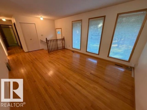 Hardwood flooring throughout, three angled windows with wood trim, and a wood spindle railing - 3 Morgan Crescent, St. Albert, AB 