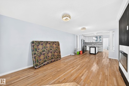 Hardwood flooring throughout, contemporary ceiling light fixtures, modern kitchen cabinetry, stainless steel appliances, and a built-in fireplace - Edmonton, AB 