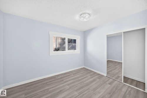 Laminate wood-finish flooring, white trim, sliding mirrored closet doors, and recessed lighting - Edmonton, AB 