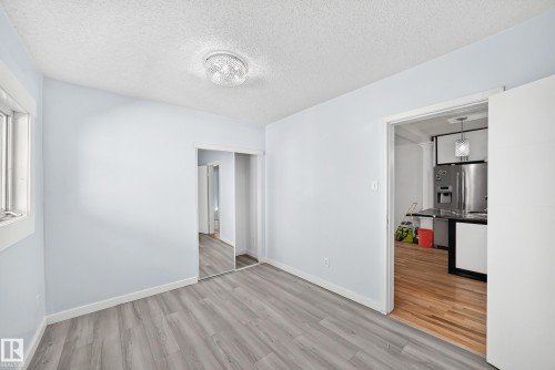 Room with wood-finish flooring, a window with white trim, and a ceiling-mounted light fixture - Edmonton, AB 