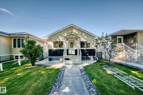 Siding exterior with a stone veneer accent, concrete walkway, and landscaped front yard - Edmonton, AB 