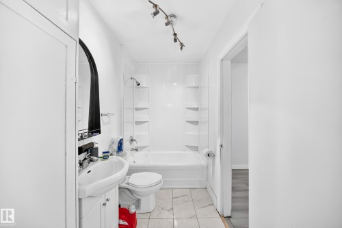 Bathroom featuring a shower-tub combination, track lighting, a vanity with an integrated sink, and tiled flooring - Edmonton, AB 