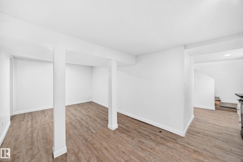 Expansive interior featuring wood-finish flooring, white walls, and a recessed ceiling - Edmonton, AB 